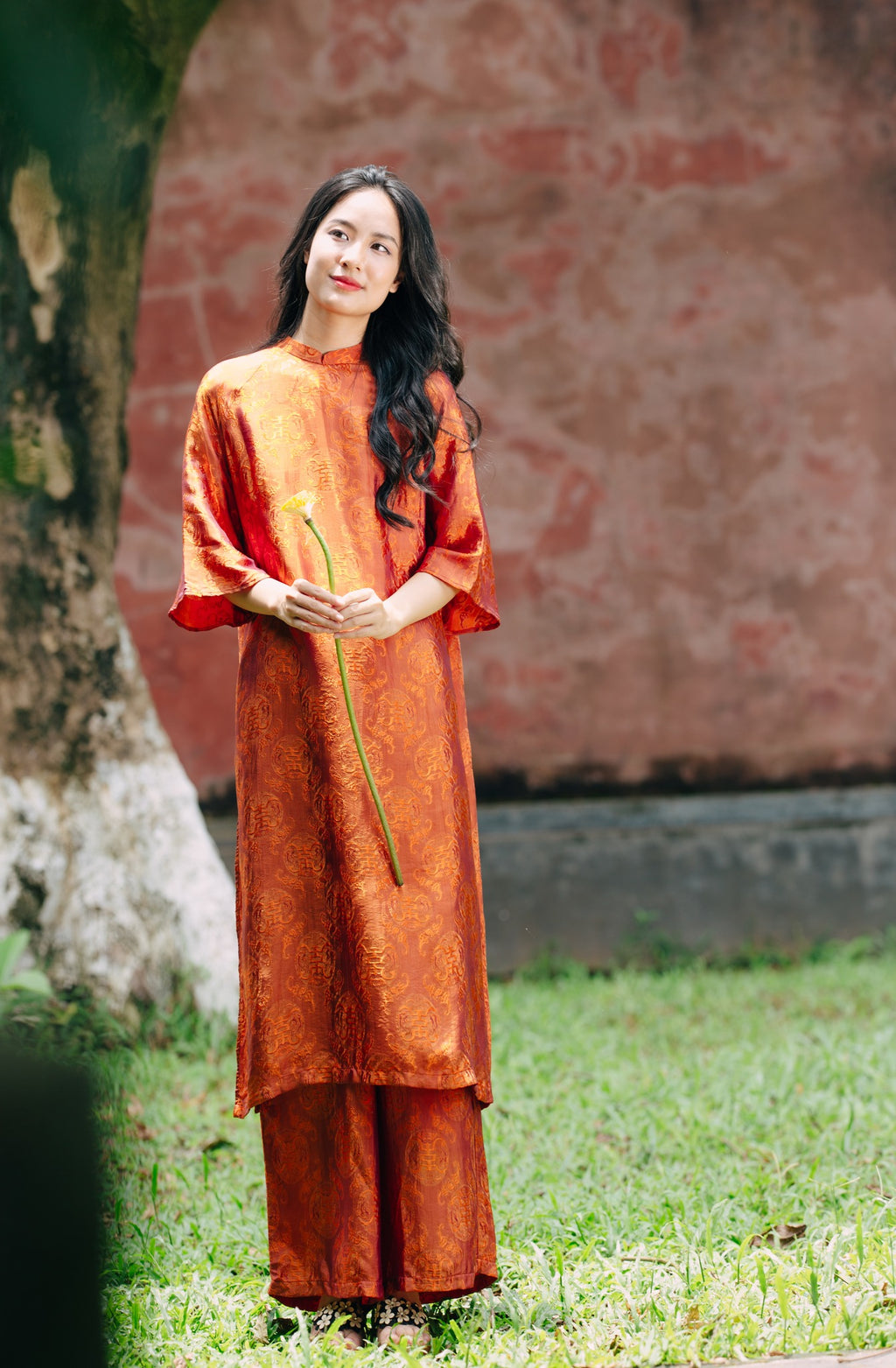 "Tho Doi Ao Dai set in orange wormsilk, traditional Vietnamese dress by Moc, artisan jacquard design."