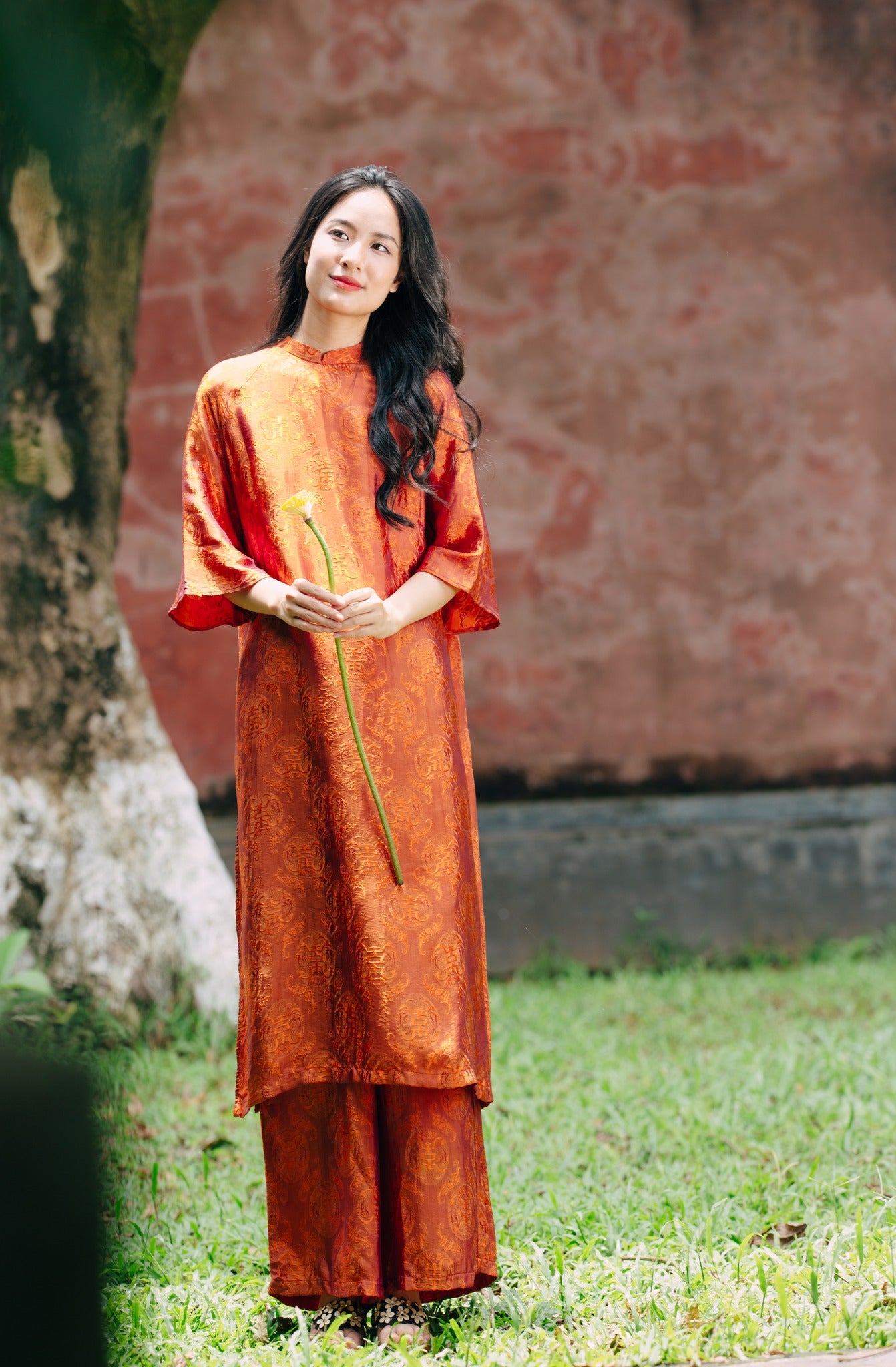 "Tho Doi Ao Dai set in orange wormsilk, traditional Vietnamese dress by Moc, artisan jacquard design."