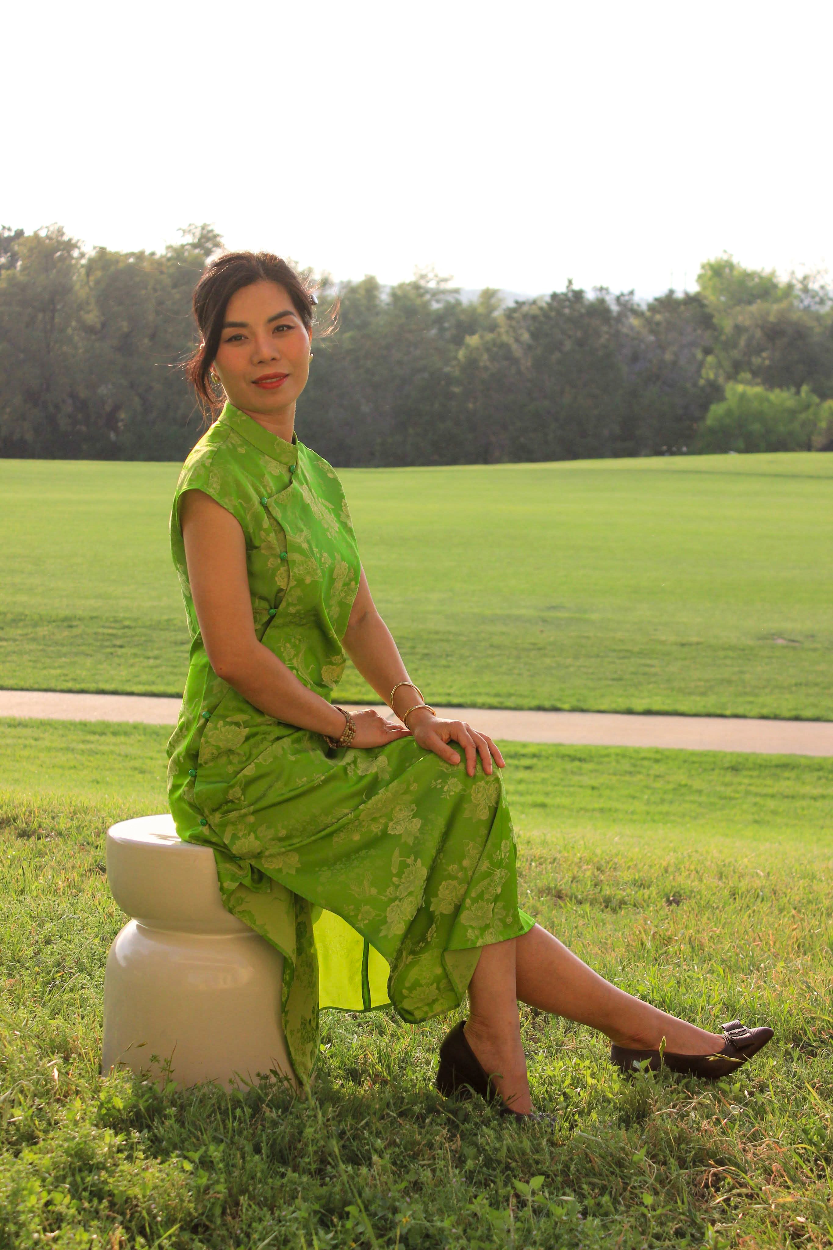 "Hương Trầm sleeveless cheongsam in green silk jacquard, modern Vietnamese design"