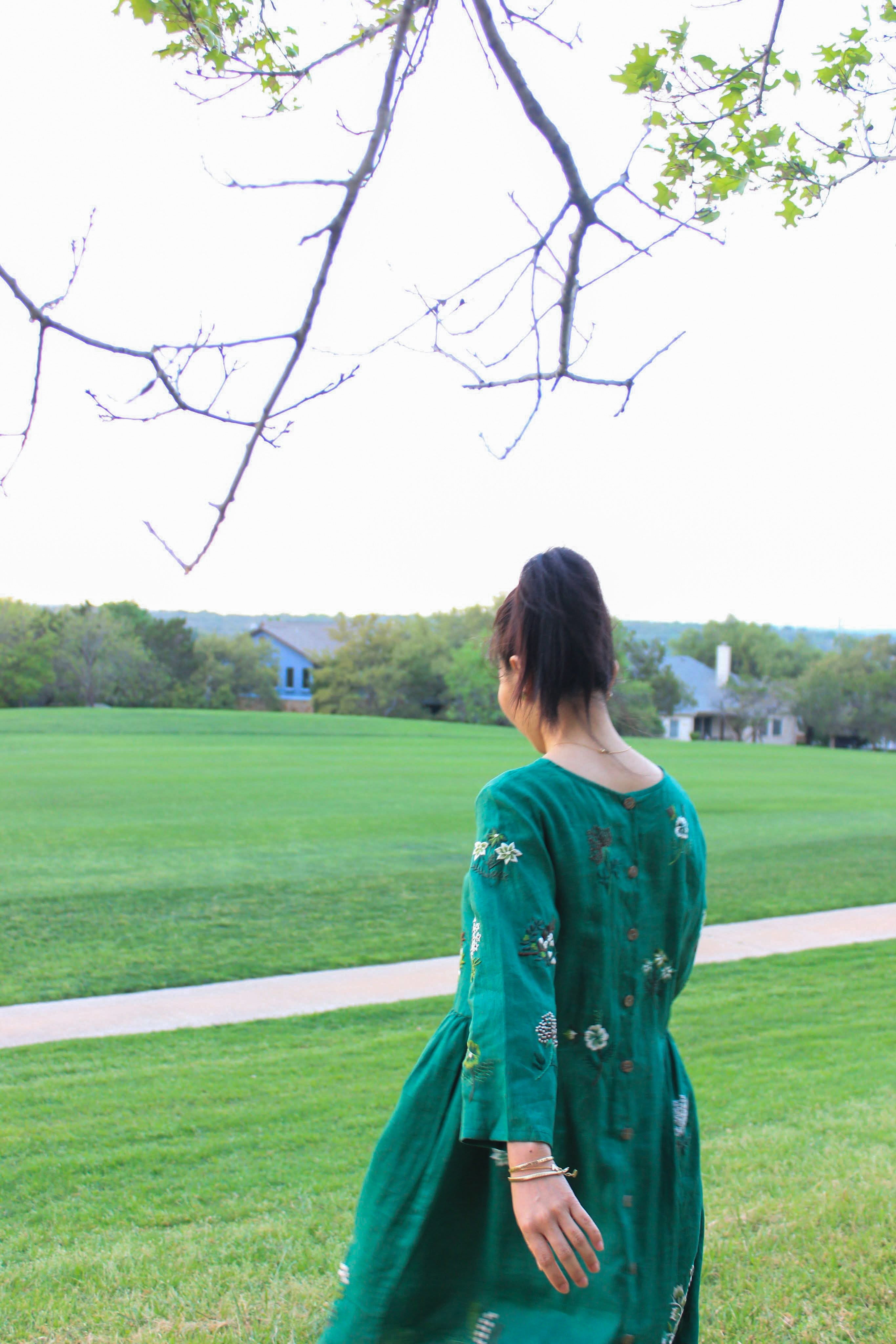 "Mimosa" embroidered green linen dress by Huulala, featuring floral patterns, Vietnamese cultural design.
